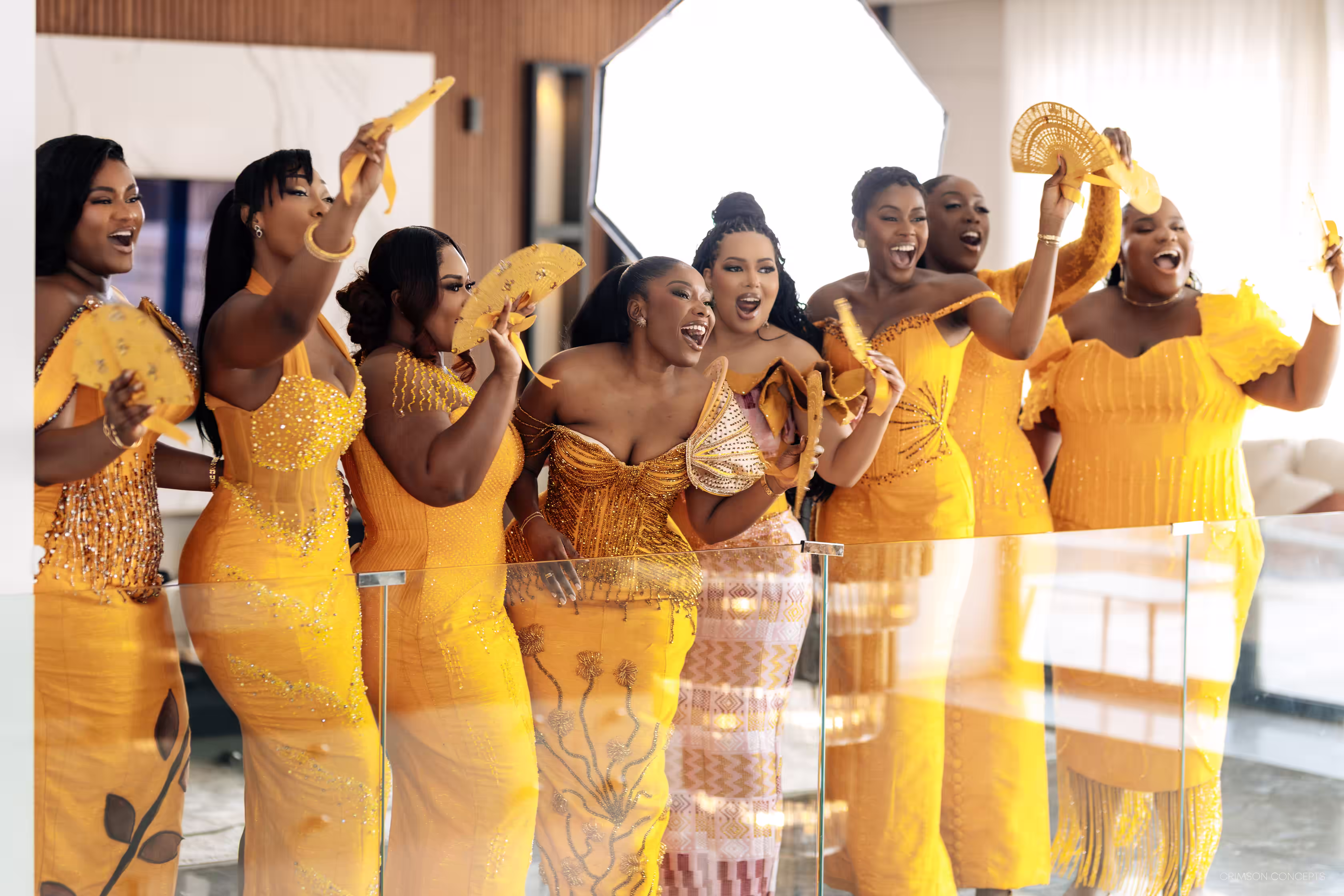The full bridal party cheering in matching gold gowns