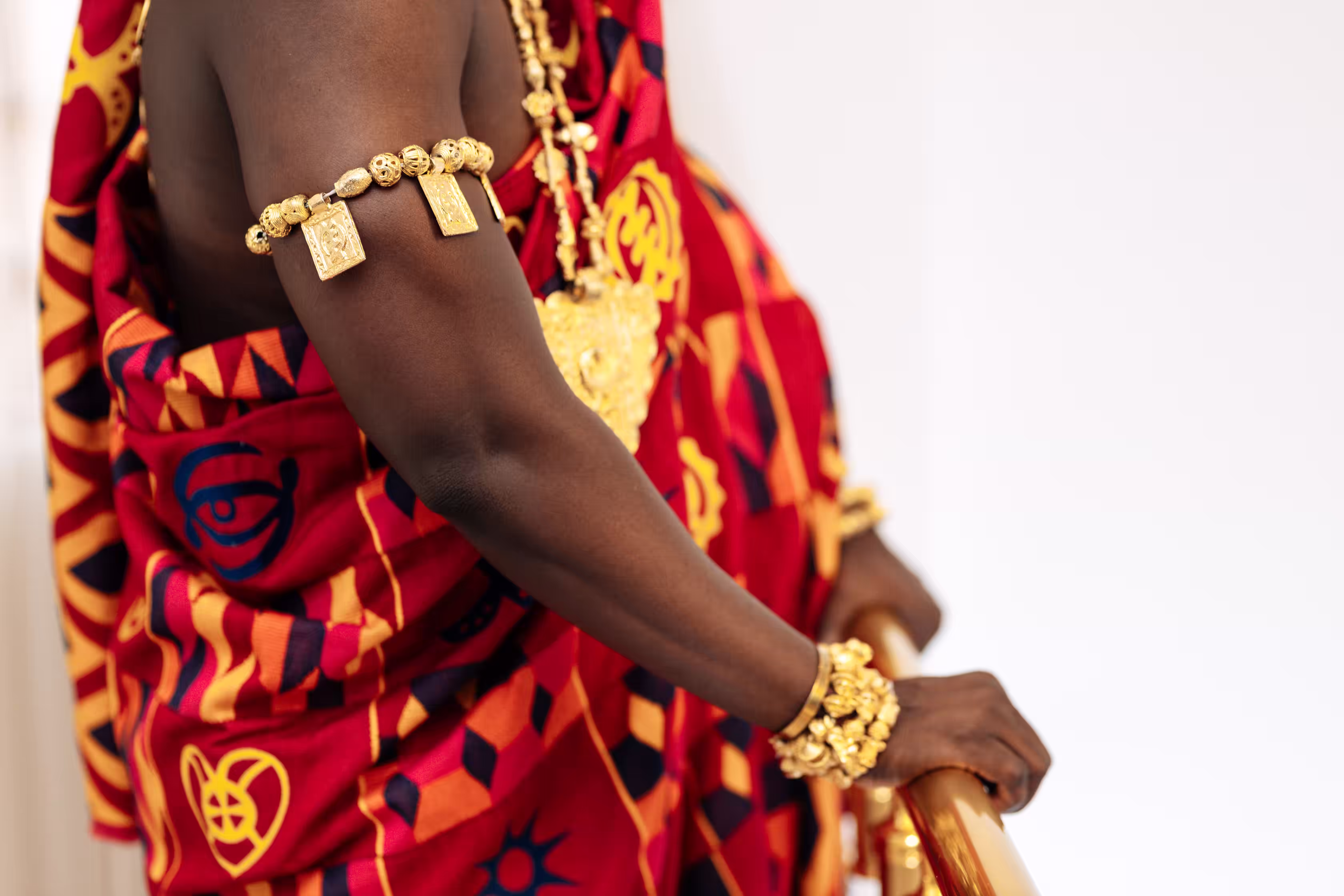 Detail of traditional gold jewelry worn over Qojoh's kente cloth